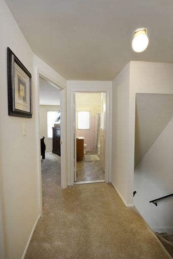 a view from the bottom of the stairs looking into the hallway of the apartment